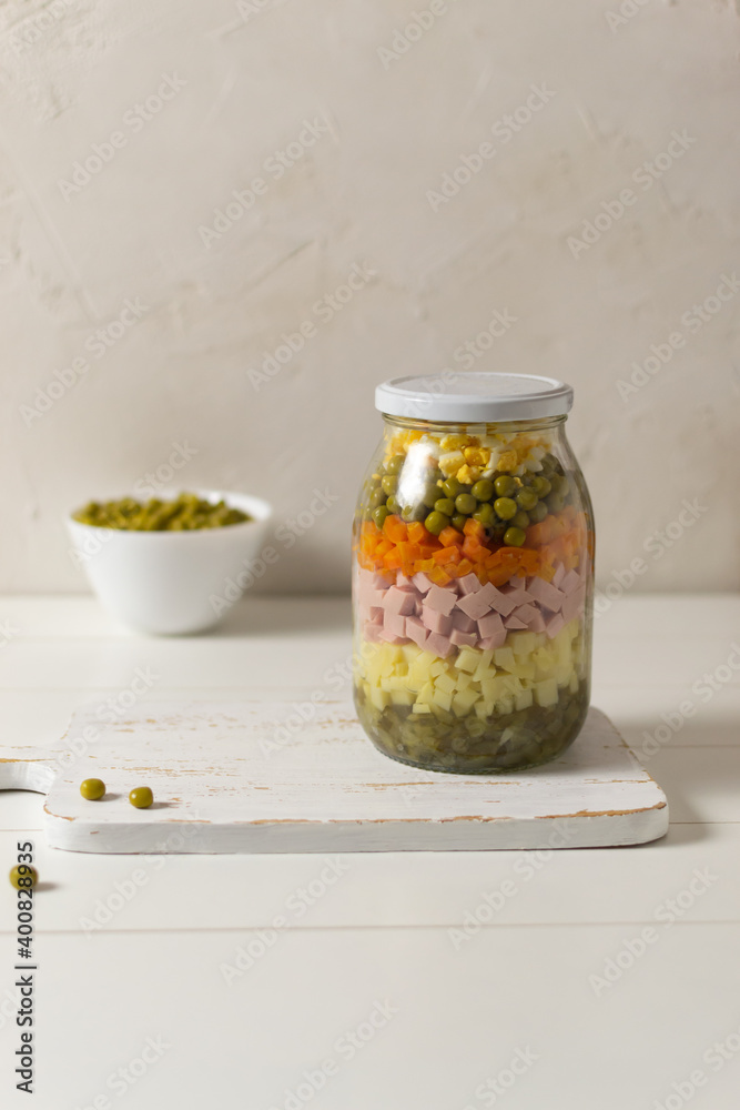 Ingredients for Olivier salad russian in a glass jar on a white background. Russian cuisine. Copy space. Ingredients for Olivier salad russian in a glass jar on a white background. Russian cuisine. Copy space.