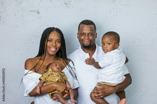 A beautiful African-American young family with two children. The oldest son is a toddler and the new infant newborn son is only a few weeks old.