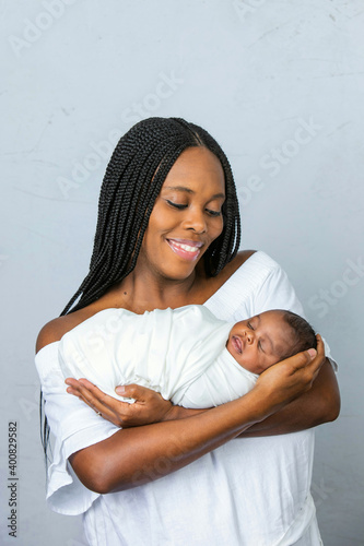 Canvas Print A beautiful African-American new mom holding and cradling her newborn son and lo