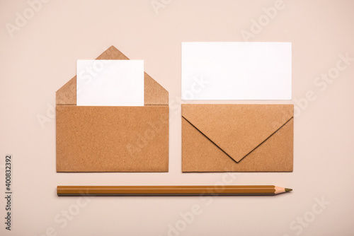 Brown paper envelopes with white cards and brown pencil