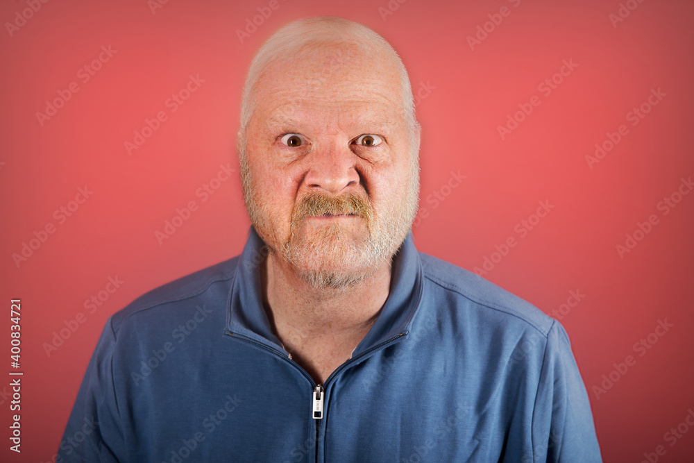 Angry old white man in front of a red background Angry old white man in front of a red background
