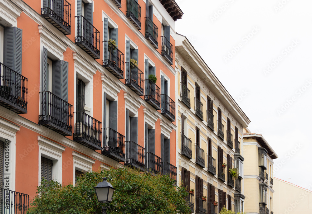 Brown and beige building facades with small balconies in downtown Madrid street. Residential neighborhood, real estate business concepts