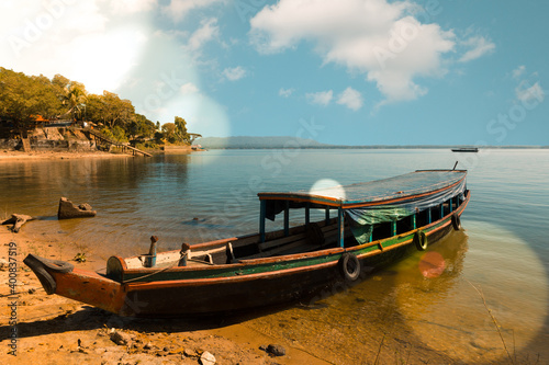 Passenger boat anchored onshore during a sunny day