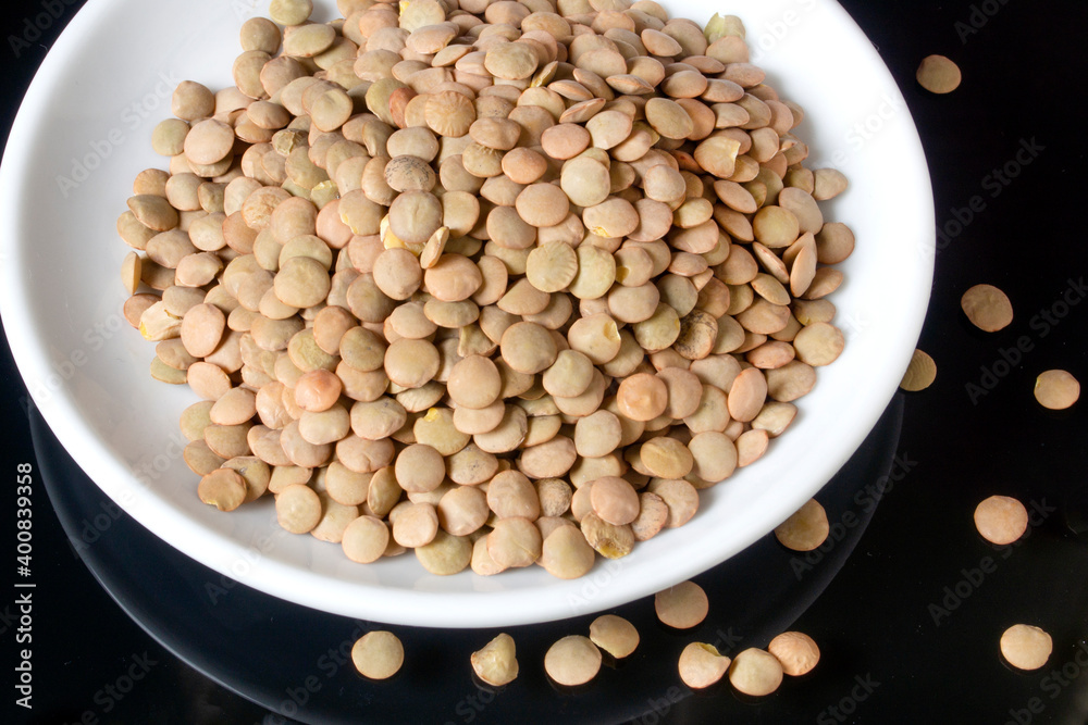 lentils on a white plate, the plate is on a glass table lentils on a white plate, the plate is on a glass table