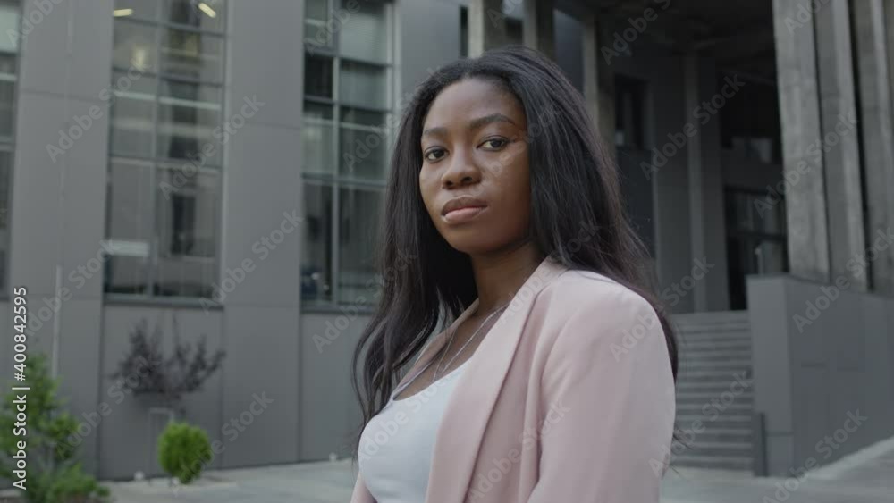 Beautiful Young Black Girl Stands On The Street. Pretty Serious Girl With Long Hair. Beautiful Young Black Girl Stands On The Street. Pretty Serious Girl With Long Hair.