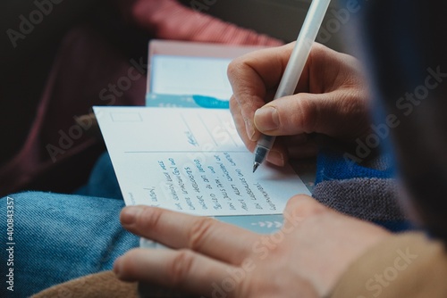 Hand of Person Writing Postcard