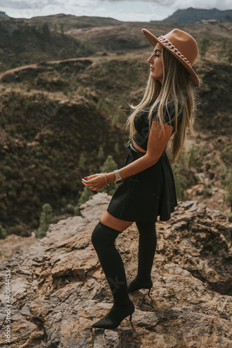 young woman with hat in the field looking at the camera