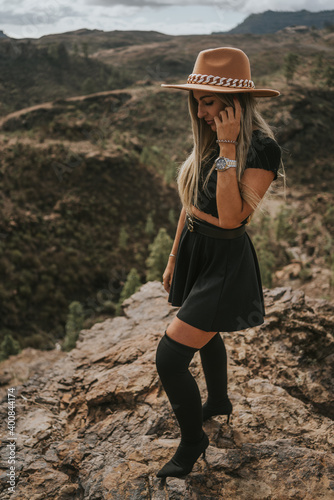 young woman with hat in the field looking at the camera