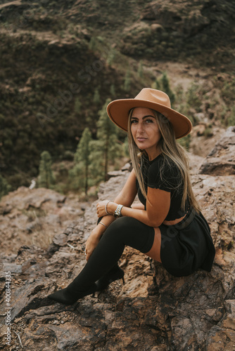 young woman with hat in the field looking at the camera