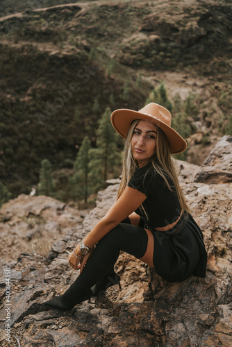young woman with hat in the field looking at the camera