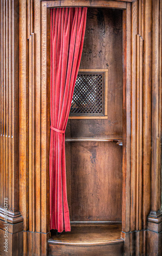 Fotótapéta wooden confessional with red velvet curtain