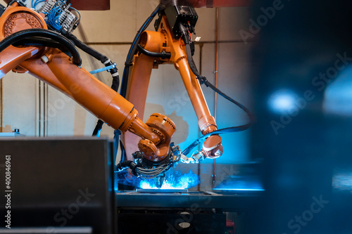 Orange color robotic arms manufacturing in industrial factory photo
