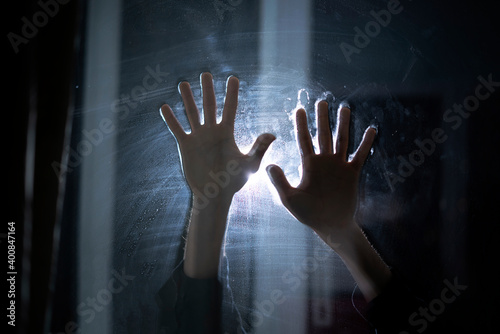 creepy horror scene, person's hands in the dark behind the glass, abstract shadow fear