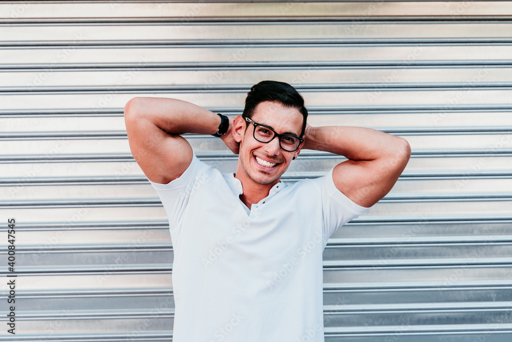 Smiling male with hand in hair against shutter Smiling male with hand in hair against shutter