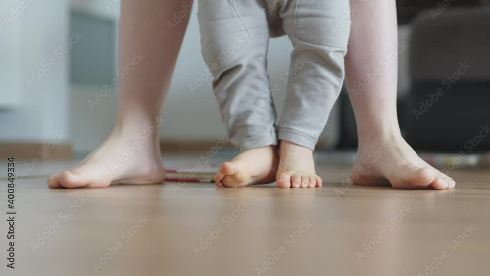Mother helping her adorable son to make his first steps. Baby crawl away. High quality 4k footage Mother helping her adorable son to make his first steps. Baby crawl away. High quality 4k footage