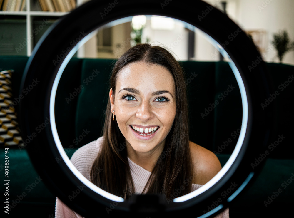 Happy female influencer with illuminated lighting equipment at home Happy female influencer with illuminated lighting equipment at home
