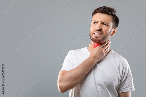Sick man having sore throat, looking at copy space