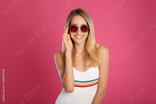 Beautiful woman in stylish sunglasses on pink background