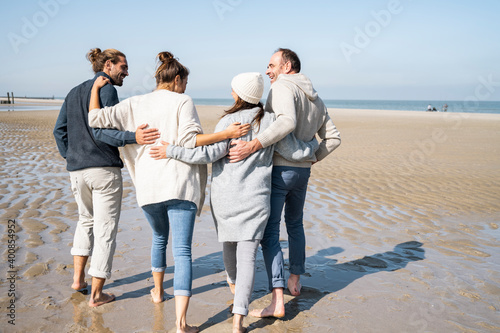 Young and mature couple with around walking at beach