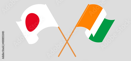 Crossed and waving flags of Japan and Republic of Ivory Coast
