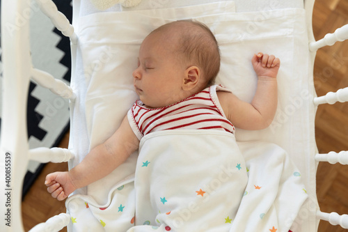 High angle view of baby girl lying down in crib at home photo