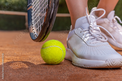 close-up on tennis player on court, racket, ball and shoes