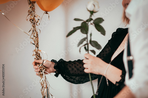 Frau hält Luftballons und Rose während Feierlichkeit