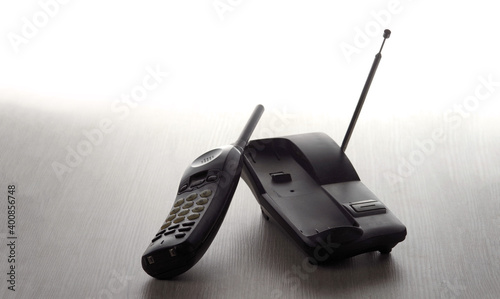 Wireless cordless telephone off the hook on a light wooden background. photo