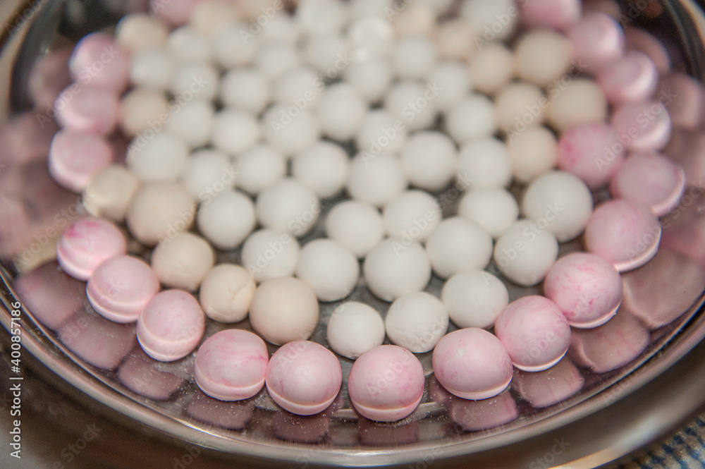 Top side view of red and white tangyuan (tang yuan, glutinous rice dumpling balls) in steel bowl for Winter solstice festival food. Top side view of red and white tangyuan (tang yuan, glutinous rice dumpling balls) in steel bowl for Winter solstice festival food.