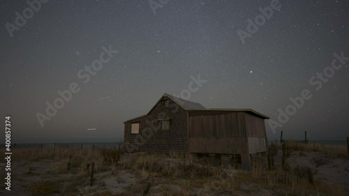Shootings stars and planes passing over an abandoned shack during Geminid Meteor Shower 