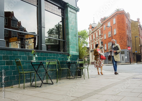 Male and female coworkers talking while walking on footpath in city photo