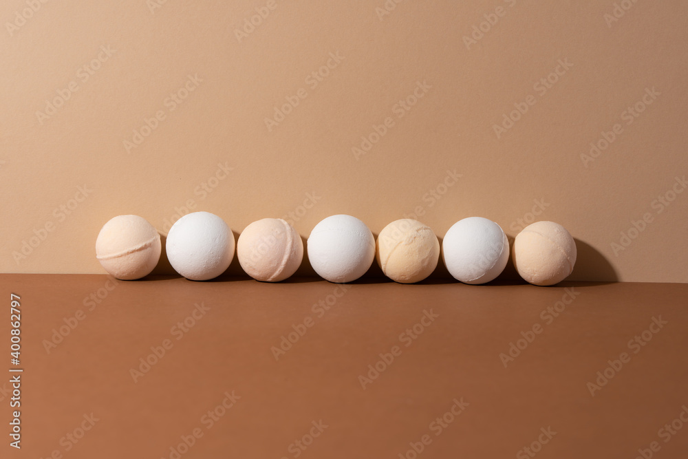The organic bath bombs with shadow on beige background. Spa concept. Presents for body. Space for text. The organic bath bombs with shadow on beige background. Spa concept. Presents for body. Space for text.