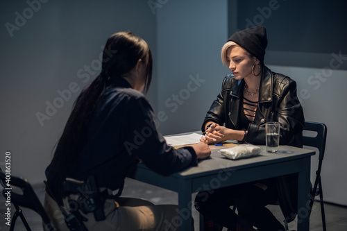 Photography A young police officer is interrogating a girl suspected of distributing drugs