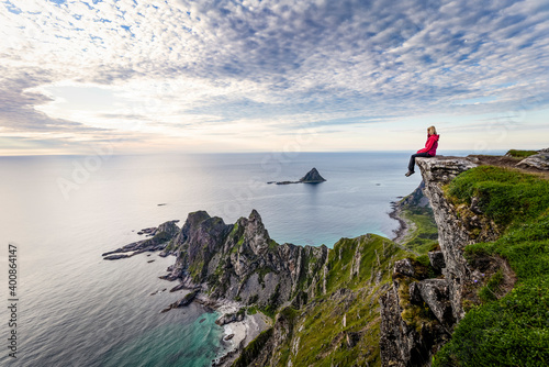 Explorer admiring view while sitting on Matind mountain at Andoya, Norway photo