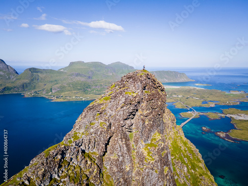 Woman standing on mountain peak at Volandstinden, Lofoten, Norway photo