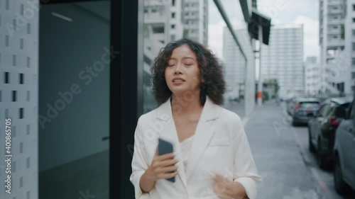 Young Indian Businesswoman in hurry running to work. Busy Asian Businessperson running late for work or meeting and looking at time in the street. 