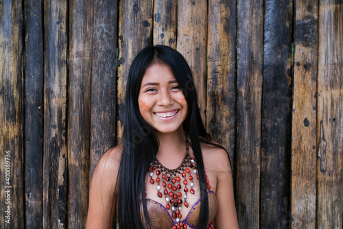 Happy young Guarani woman against bamboo wall, Misahualli, 
Ecuador