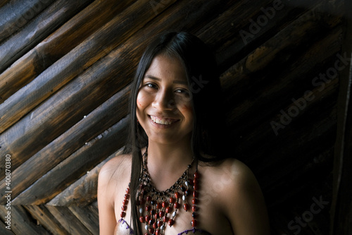 Smiling young Guarani woman against bamboo wall, Misahualli, 
Ecuador photo