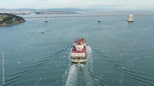 San Francisco, USA. Aerial view of large cargo ship approaching to the bridge. Panoramic vista of maritime commerce operating. High quality 4k footage photo