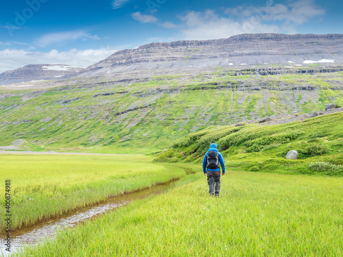 Male backpacker hiking along stream toward Drangajokull photo