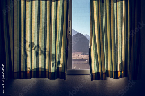 Window covered by green striped curtains photo