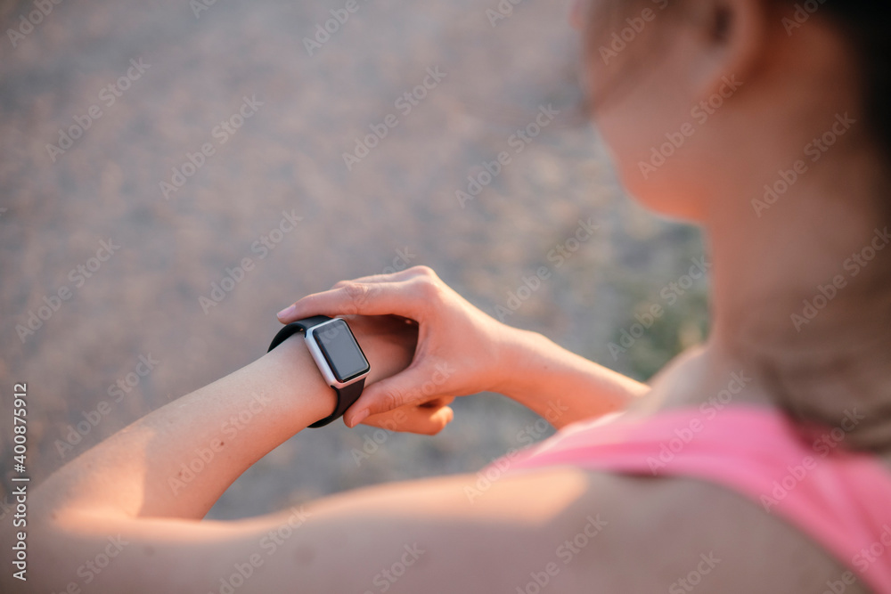 Fit young athlete checking tome on smart watch Fit young athlete checking tome on smart watch