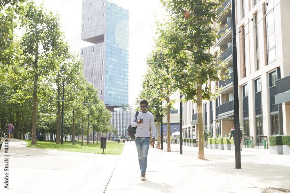 custom made wallpaper toronto digitalMale commuter listening music while walking on footpath in financial district