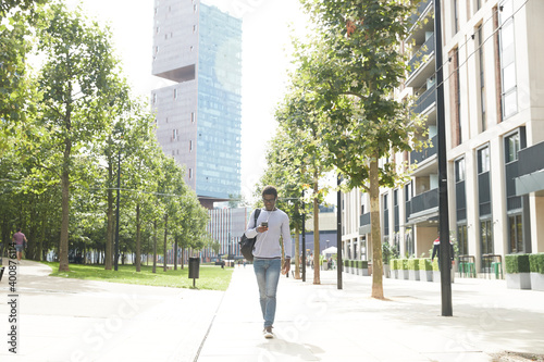 Wallpaper Mural Male commuter listening music while walking on footpath in financial district Torontodigital.ca