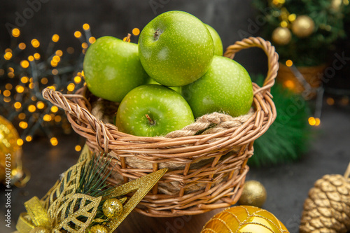 Fototapeta Naklejka Na Ścianę i Meble -  front view fresh green apples around christmas toys on dark background color photo xmas holiday fruit