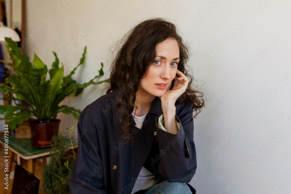 Beautiful woman with hand on chin sitting at home Beautiful woman with hand on chin sitting at home