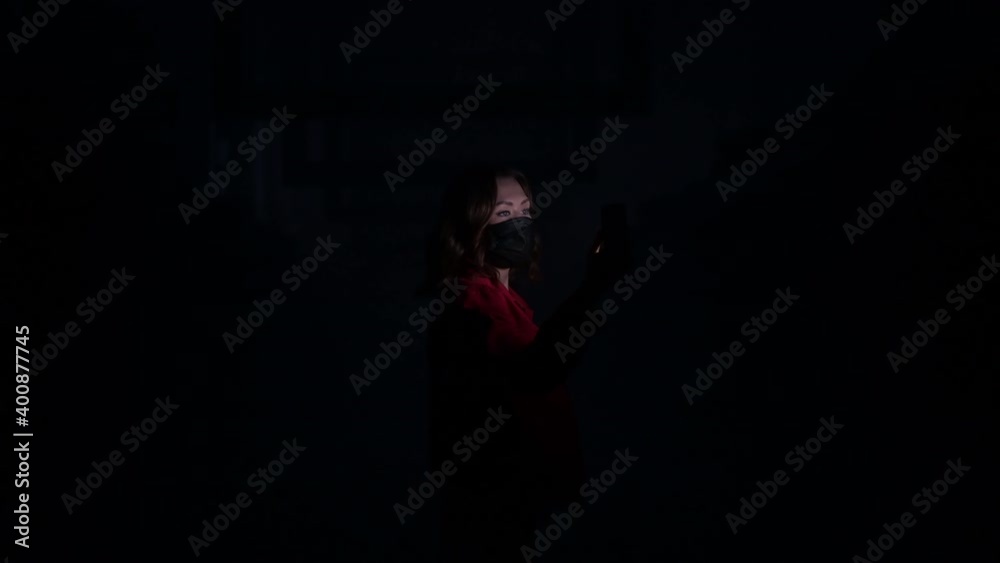 Woman in a face mask using mobile phone hacking abstract big data center remotely. Light effects and glitches on a background. Cyberpunk and cybersecurity concept. Woman in a face mask using mobile phone hacking abstract big data center remotely. Light effects and glitches on a background. Cyberpunk and cybersecurity concept.