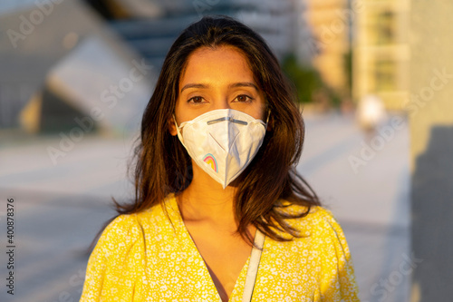 Confident young woman wearing face mask in city
