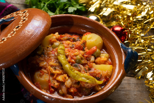 Mexican style cod called a la vizcaina on wooden background