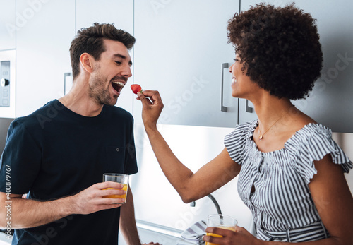 Tender interracial couple feeding each other with berries